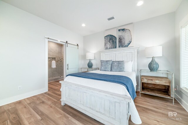 3238 Sea Horse Cir, Gulf Shores, AL 36542 - bedroom with a barn door, recessed lighting, baseboards, wood finished floors, and visible vents