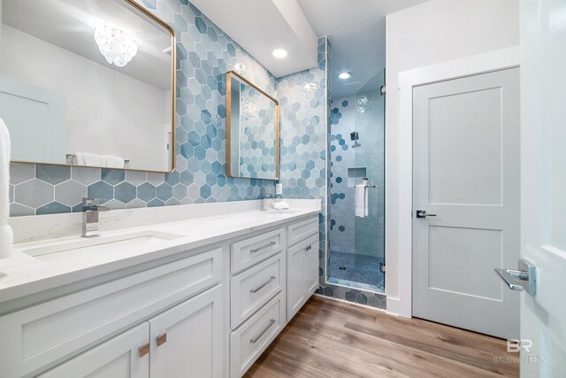 3238 Sea Horse Cir, Gulf Shores, AL 36542 - bathroom with a sink, double vanity, a shower stall, wood finished floors, and tasteful backsplash