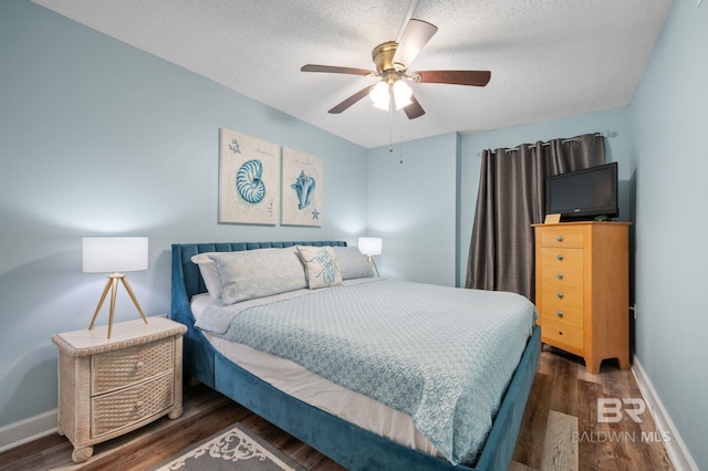 517 E Beach Blvd Unit 1B, Gulf Shores, AL 36542 - bedroom featuring dark wood-style floors, baseboards, a textured ceiling, and ceiling fan