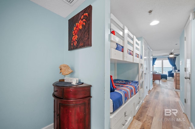 517 E Beach Blvd Unit 1B, Gulf Shores, AL 36542 - bedroom with light wood-type flooring, baseboards, a textured ceiling, and french doors
