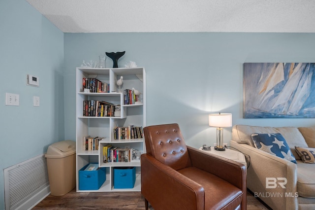 517 E Beach Blvd Unit 1B, Gulf Shores, AL 36542 - sitting room with wood finished floors, baseboards, and a textured ceiling