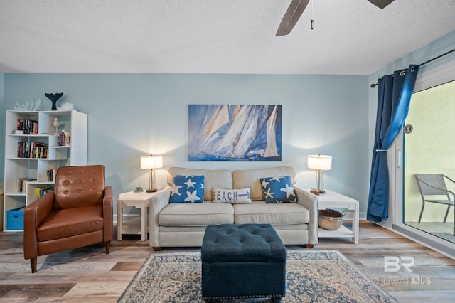 517 E Beach Blvd Unit 1B, Gulf Shores, AL 36542 - living area featuring wood finished floors, a textured ceiling, a ceiling fan, and baseboards