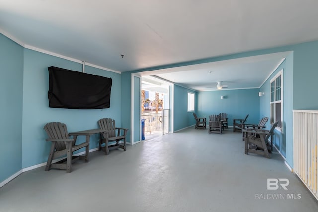 sitting room featuring concrete flooring and ceiling fan