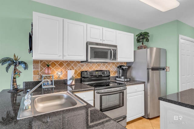 kitchen featuring sink, appliances with stainless steel finishes, light tile patterned floors, and white cabinetry