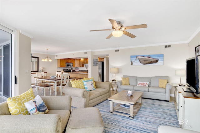 living room featuring ornamental molding and ceiling fan with notable chandelier