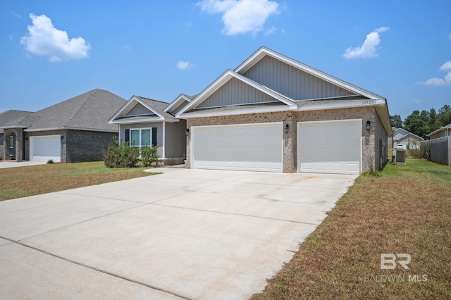 view of front facade featuring a front lawn, central AC unit, and a garage