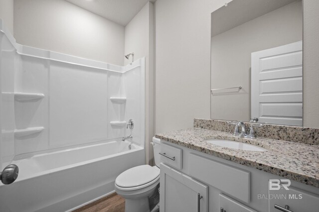 full bathroom with hardwood / wood-style floors, toilet, shower / bathtub combination with curtain, and vanity