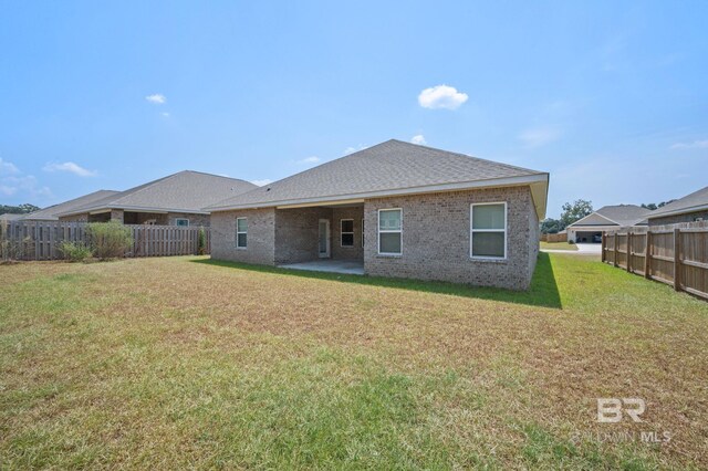 back of property featuring a lawn and a patio