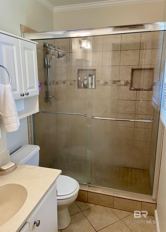 bathroom featuring toilet, tile patterned floors, an enclosed shower, crown molding, and vanity