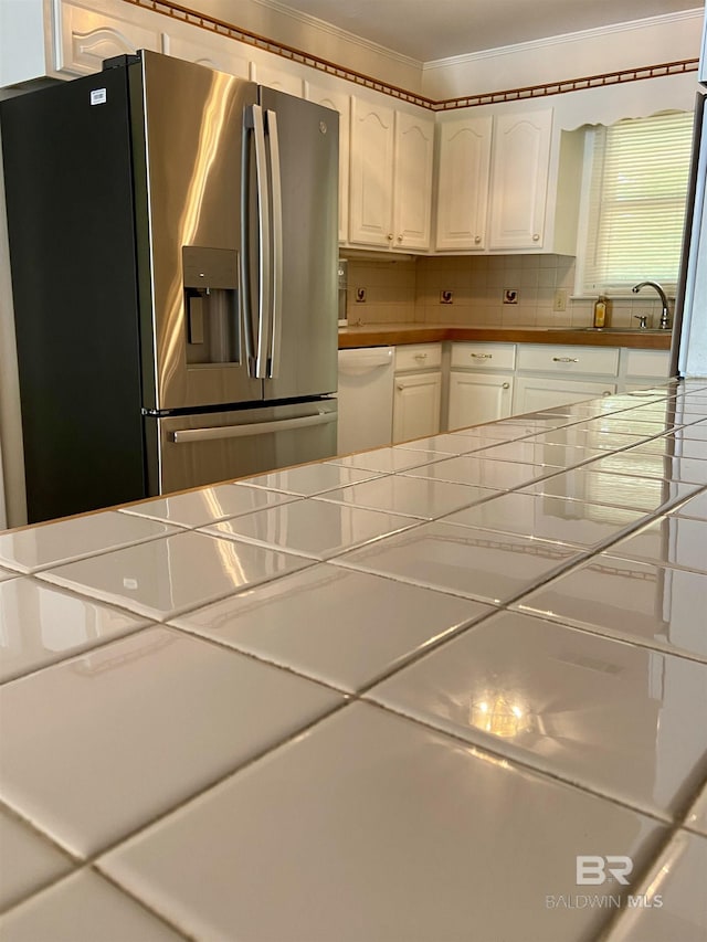 kitchen featuring white cabinetry, tile countertops, stainless steel refrigerator with ice dispenser, tasteful backsplash, and dishwasher