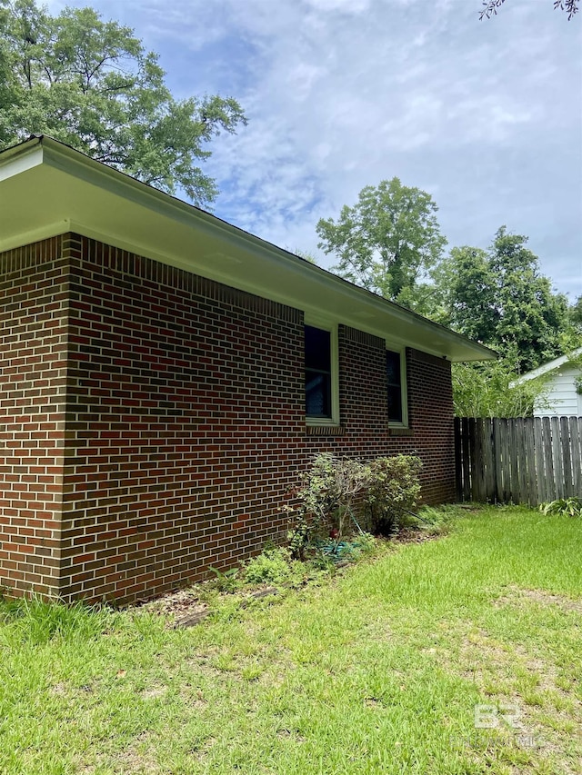 view of side of home with a yard