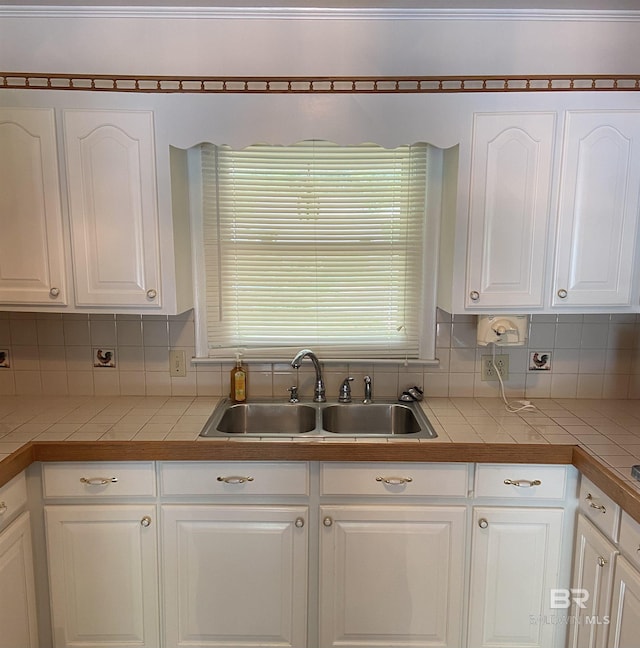 kitchen featuring white cabinetry, tasteful backsplash, and sink