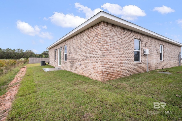 view of home's exterior featuring central AC unit and a lawn