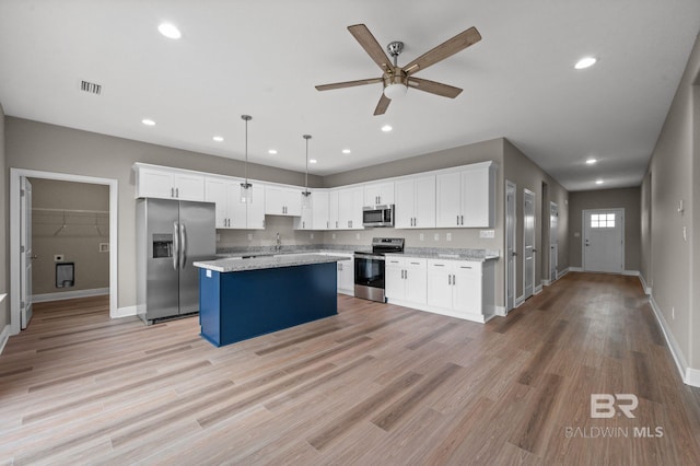 kitchen featuring stainless steel appliances, decorative light fixtures, a kitchen island, white cabinets, and light wood-type flooring