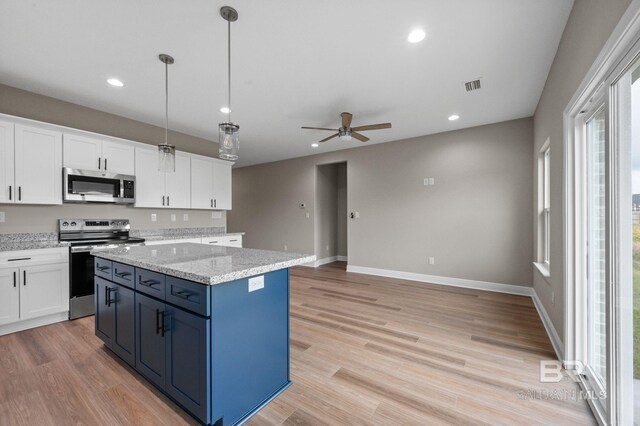 kitchen with white cabinetry, appliances with stainless steel finishes, and light hardwood / wood-style floors