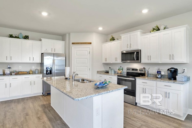 kitchen with appliances with stainless steel finishes, light wood-style floors, white cabinets, and a sink