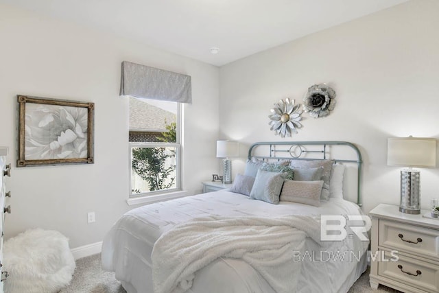 bedroom with light carpet and baseboards