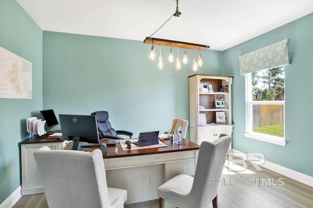 office area with baseboards and wood finished floors