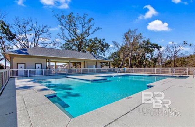 community pool featuring a patio area and fence