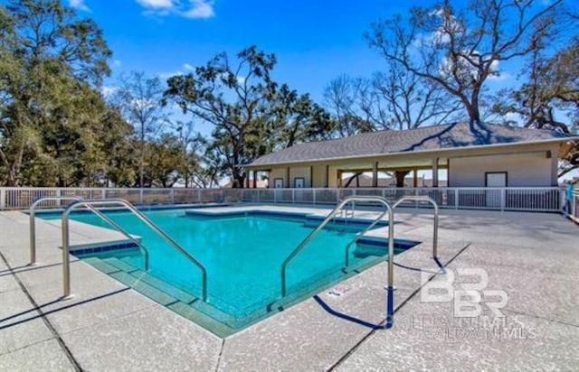 pool with a patio area and fence