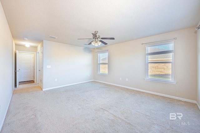 spare room featuring ceiling fan and light carpet