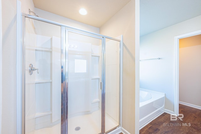 bathroom with hardwood / wood-style flooring and plus walk in shower