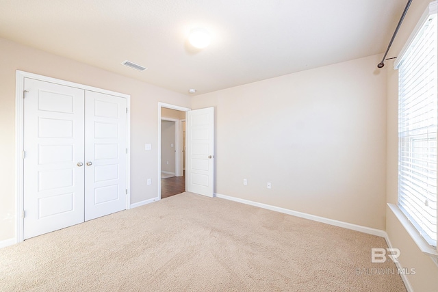 unfurnished bedroom featuring carpet floors and a closet