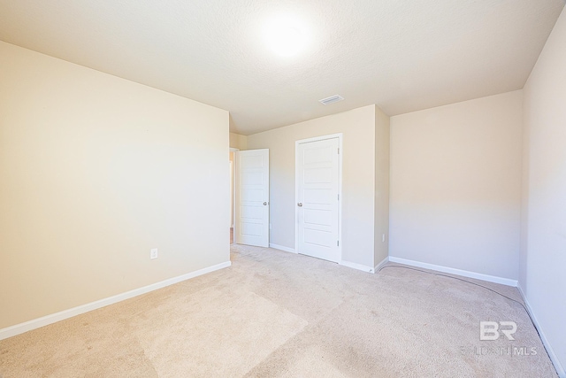 carpeted spare room with a textured ceiling