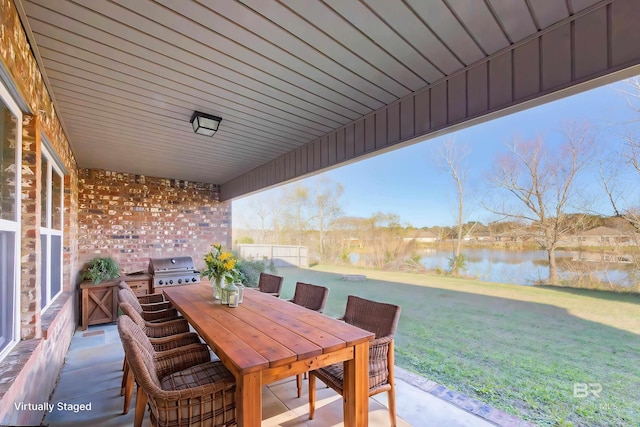 view of patio with grilling area and a water view