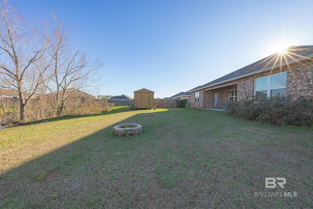 view of yard featuring a storage shed and an outdoor fire pit