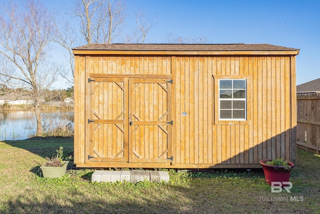 view of outdoor structure with a yard and a water view