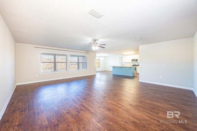 unfurnished living room with ceiling fan and dark wood-type flooring