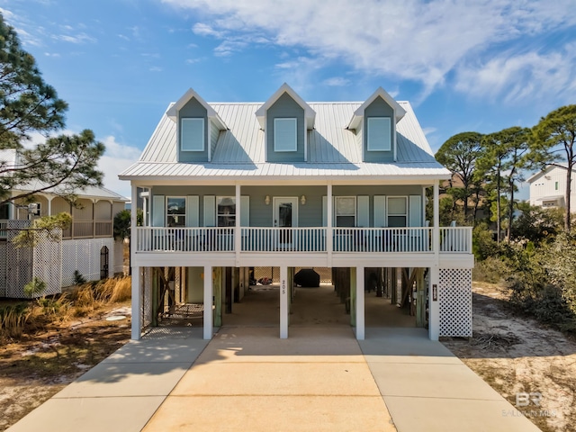 coastal inspired home featuring a carport, covered porch, and concrete driveway