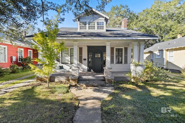 bungalow-style house with a porch and a front lawn