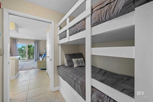 1117 W Beach Blvd Unit 201, Gulf Shores, AL 36542 - bedroom with baseboards and tile patterned floors