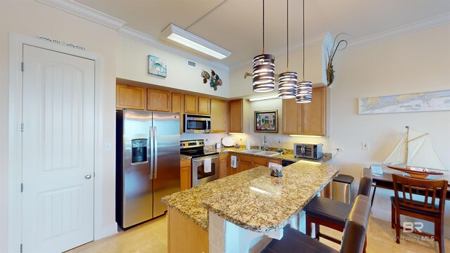 kitchen with pendant lighting, appliances with stainless steel finishes, light stone countertops, crown molding, and a kitchen bar