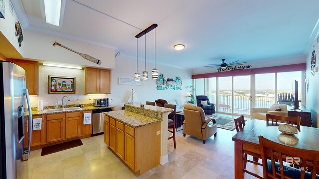 kitchen with ceiling fan, sink, decorative light fixtures, stainless steel appliances, and light stone countertops