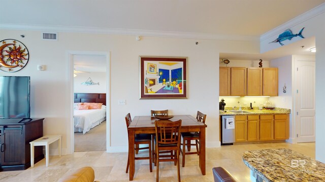 dining space featuring sink and crown molding