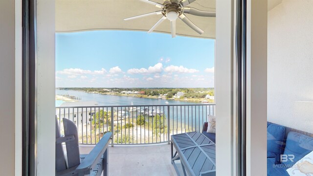 balcony with ceiling fan and a water view