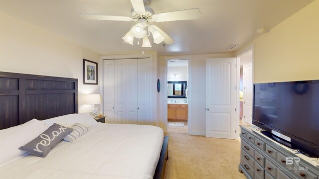 bedroom with ceiling fan, connected bathroom, and light carpet