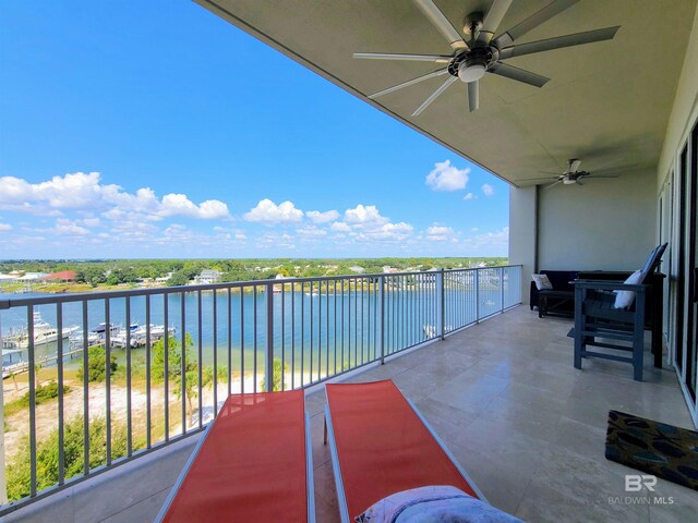 balcony featuring ceiling fan and a water view