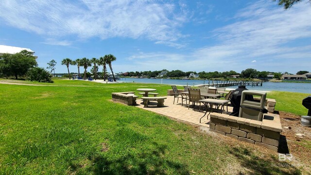 view of property's community with a water view, a yard, and a patio area