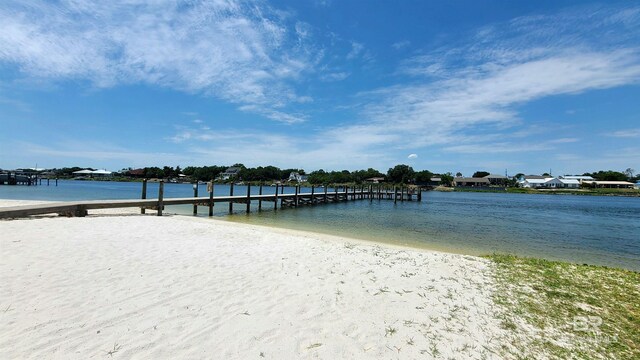 dock area featuring a water view and a beach view