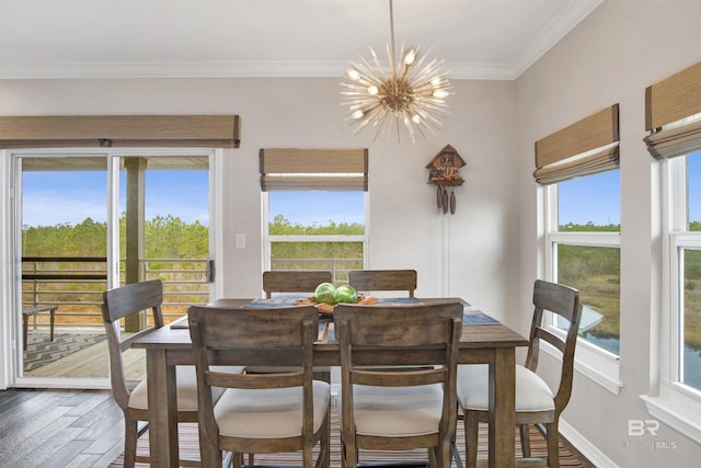 dining room featuring baseboards, ornamental molding, wood finished floors, and an inviting chandelier