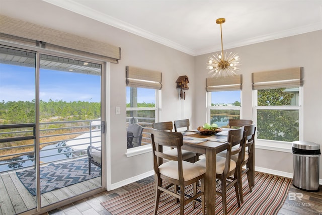 dining space featuring baseboards, a chandelier, crown molding, and wood finished floors