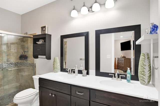 full bath with toilet, a stall shower, double vanity, and a sink