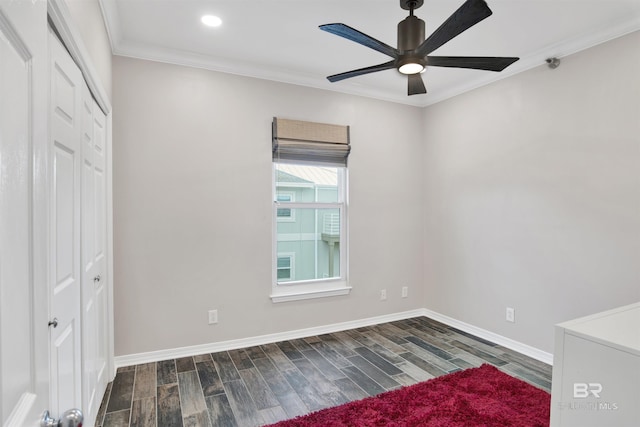 unfurnished bedroom featuring ornamental molding, dark wood-type flooring, a closet, and baseboards