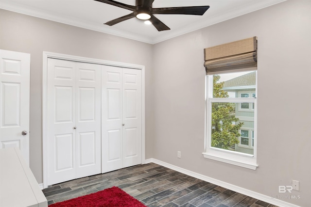 unfurnished bedroom featuring wood finish floors, a closet, crown molding, and baseboards