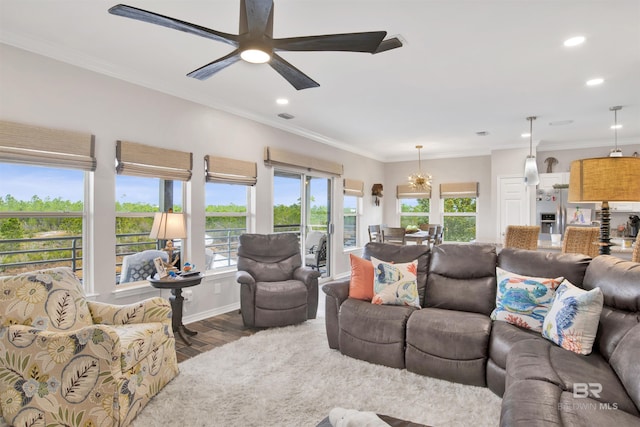 living room with recessed lighting, baseboards, ornamental molding, wood finished floors, and ceiling fan with notable chandelier