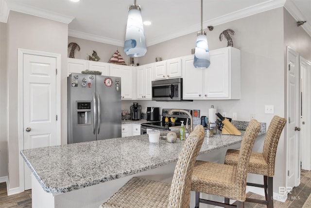 kitchen featuring white cabinets, appliances with stainless steel finishes, ornamental molding, a peninsula, and light stone countertops